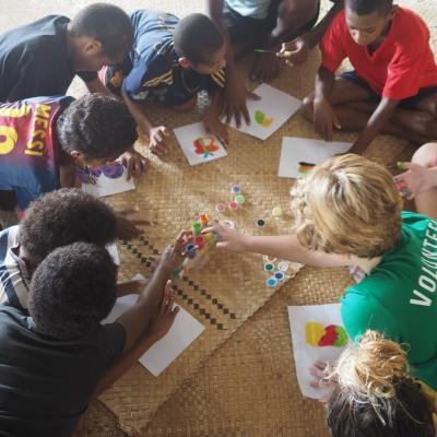 Projects Abroad volunteer completes community work for teenagers in Fiji while helping the children with finger painting lessons A volunteer and her students play with finger paints during her volunteer work with children for teenagers in Fiji